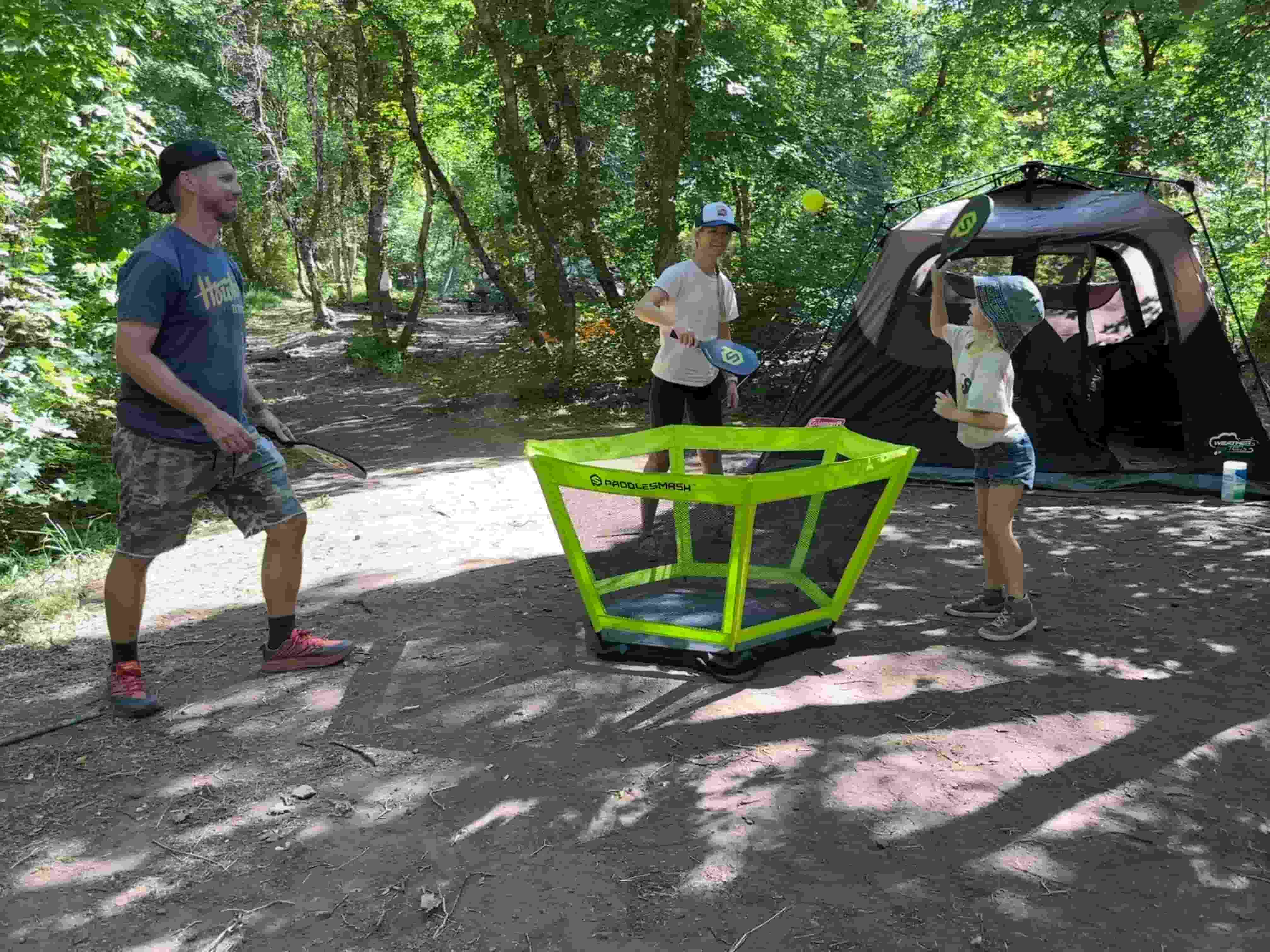 Dad and kids playing PaddleSmash at a campsite